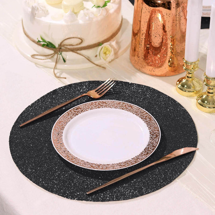 Black glitter placemat with a decorative plate and rose gold cutlery.