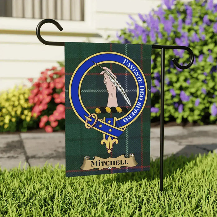 Mitchell Family Crest garden flag displayed in a flower bed