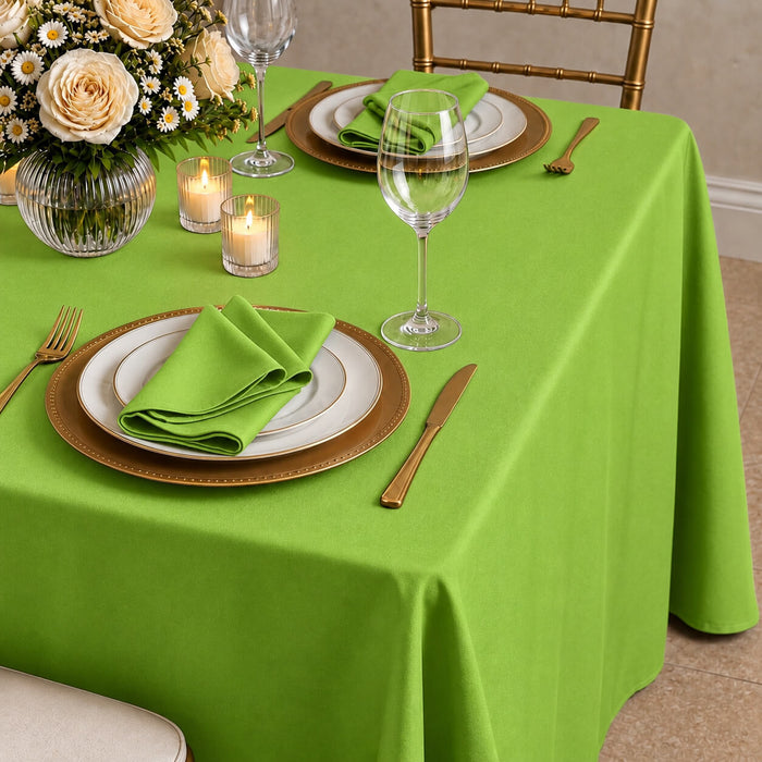 Apple green polyester tablecloth on a dining table with decor.